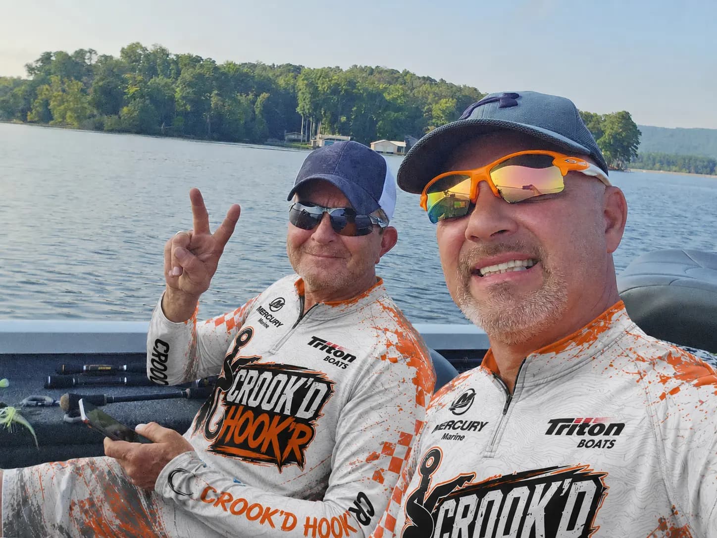 Matt and T on the boat wearing their orange-and-white Crook’d Hook’r jerseys